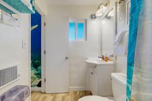 a white bathroom with a toilet and a sink at Lamplighter Inn - 115 Turtle Bay in Bandon
