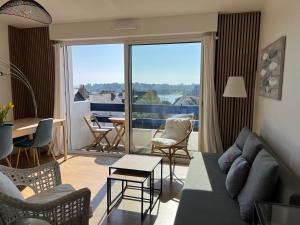 a living room with a couch and a large window at Appartement vue mer in Bénodet