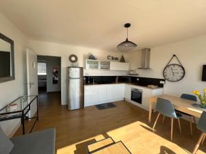 a kitchen with white cabinets and a table and a tableablish at Appartement vue mer in Bénodet