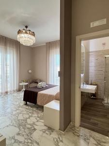 a bedroom with a bed and a chandelier at Faro Bianco Gallipoli - Suites & Apartments in Gallipoli +291 photos
