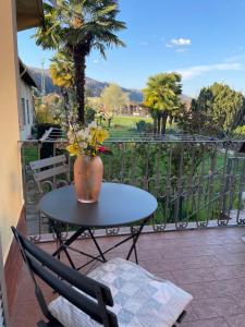 ein Tisch mit einer Vase darauf auf einem Balkon in der Unterkunft Piccolo Relax in Meina