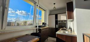 eine Küche mit großem Fenster und Spüle in der Unterkunft Zakątek w Centrum Suwałk in Suwałki