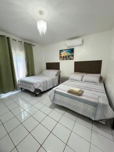 a bedroom with two beds and a chandelier at Casa Herminia in Omoa +55 photos