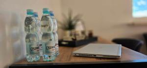 zwei Flaschen Wasser und ein Laptop auf einem Tisch in der Unterkunft Zakątek w Centrum Suwałk in Suwałki + 6 Fotos
