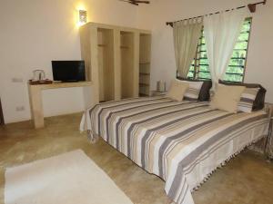 a bedroom with a large bed with a window at 1, 2 bed bungalow Watamu in Watamu +22 photos
