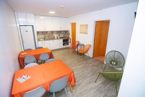a kitchen with an orange table and chairs at Hostel D'Avenida in Vila Praia de Âncora