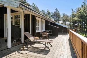 a deck with a rocking chair on a house at LF722-Hurup-Thy-Haettemagevej-22 in Sindrup