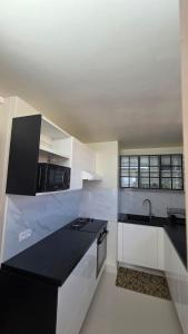 a kitchen with white cabinets and a black counter top at Villa Maxime in Sainte-Marie +10 photos