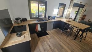 a kitchen with a wooden counter top and a table at Koa Lodge style Bali avec jacuzzi in Saint-Joseph