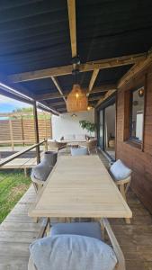 a long wooden table and chairs on a patio at Koa Lodge style Bali avec jacuzzi in Saint-Joseph