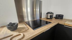 a kitchen with a counter with a sink and a appliance at Koa Lodge style Bali avec jacuzzi in Saint-Joseph +9 photos