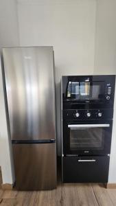 a stainless steel refrigerator next to a microwave at Koa Lodge style Bali avec jacuzzi in Saint-Joseph