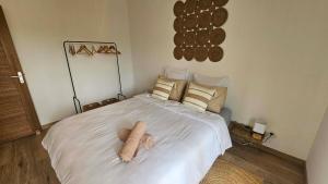 a bedroom with a bed with a teddy bear on it at Koa Lodge style Bali avec jacuzzi in Saint-Joseph