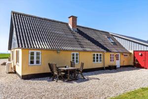a house with a table and chairs in front of it at LF10304-Hurup-Thy-Gundtoft-Mollevej-4 in Gettrup