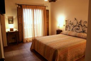 Un dormitorio con una cama grande y una ventana. en Posada La Gatera, en Pedro Bernardo