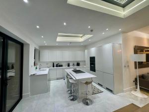 a kitchen with white cabinets and a white counter top at Stockwell Residences - The Eclipse Room in London +2 photos