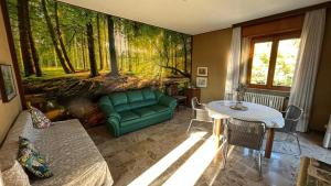 a living room with a green couch and a table at Lago Maggiore Green House in Leggiuno