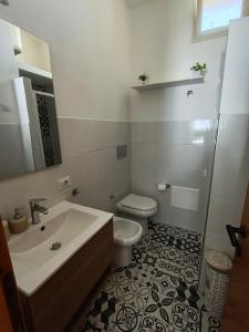 a white bathroom with a toilet and a sink at Il Mascone in Stintino