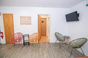 a room with chairs and a flat screen tv at Hostel D'Avenida in Vila Praia de Âncora