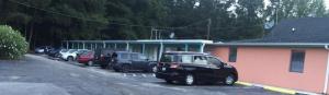 a parking lot with cars parked in front of a building at Budget Motel in Hamer