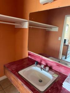 a bathroom with a sink and a mirror at Budget Motel in Hamer