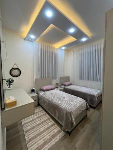 a room with two beds and a desk and a room with two beds at Bait Ajloun in Khirbat Shīn