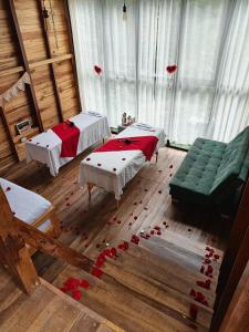 a room with two beds and a couch and roses on the floor at Cabañas AlmA Rural Ibagué in Ibagué