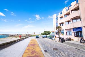 a street in front of a building next to the ocean at Hostel D'Avenida in Vila Praia de Âncora
