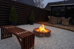 a fire pit and a bench in a backyard at Slava Spa Relax House in Nakskov