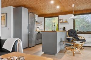 a kitchen with stainless steel appliances and a table and chairs at LF18112-Veslos-Jegindovej-12 in Vesløs