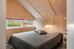 a bedroom with a bed in a room with wooden walls at LF10208-Struer-Skovstien-8 in Jegind