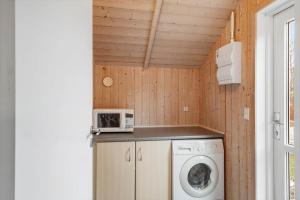 a small kitchen with a washing machine and a microwave at LF10208-Struer-Skovstien-8 in Jegind