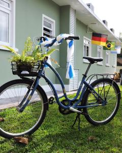 a bike parked in the grass in front of a house at Hospedagem Dona Ester in Pomerode
