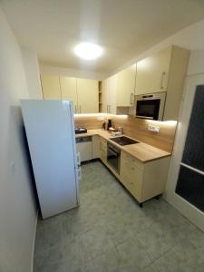 a small kitchen with a white refrigerator in it at Fasor Apartman in Kaposvár