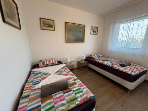 a bedroom with two beds and a window at Fasor Apartman in Kaposvár