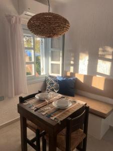 a dining room table with chairs and a chandelier at Traditional dream myconian studio in Ornos