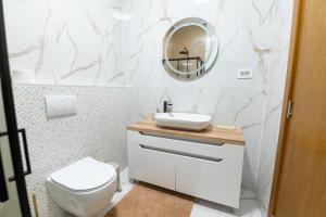 a bathroom with a white toilet and a mirror at Apartman Maxim in Palić +7 photos