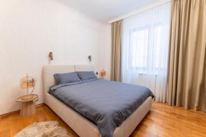 a bedroom with a bed and a large window at Apartman Maxim in Palić