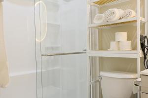 a bathroom with a shower with a toilet and towels at Bright Modern Suite in Bonavista, Private Entrance with Free Parking in Winnipeg