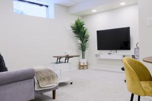 a living room with a couch and a tv at Bright Modern Suite in Bonavista, Private Entrance with Free Parking in Winnipeg +16 photos