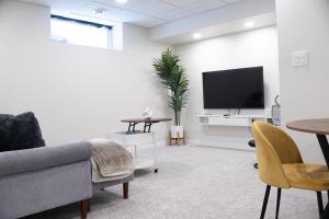 a living room with a couch and a tv at Bright Modern Suite in Bonavista, Private Entrance with Free Parking in Winnipeg
