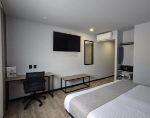 a bedroom with a bed and a desk and a television at Avanta Hotel & Villas Querétaro in Santa Rosa de Jáuregui