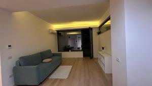 a living room with a blue couch and a mirror at Warm Apartment 1 in Bucharest +7 photos