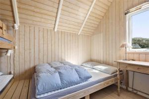 a bed in a room with a wooden wall at BV102-Blavand-Nordslugen-6 in Blåvand
