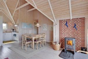 a kitchen and dining room with a table and a fireplace at BV102-Blavand-Nordslugen-6 in Blåvand +13 photos