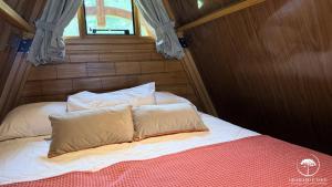a bed with two pillows on it in a room at Refúgio em Gramado | cabana c/ hidromassagem in Gramado