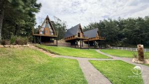 a large house with a gambrel roof and a path at Refúgio em Gramado | cabana c/ hidromassagem in Gramado