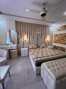 a bedroom with a bed and a couch and a mirror at apartment for rent in Islamabad