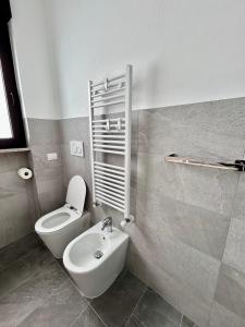 a bathroom with a toilet and a sink at NUVOLA Hosting in Segrate