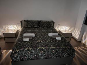 a bedroom with a large bed with two tables at NUVOLA Hosting in Segrate
